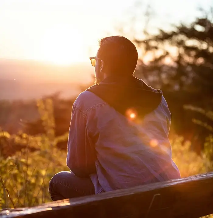 Man sitting outside at sunset