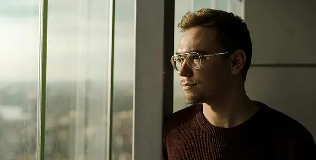 Man looking out window