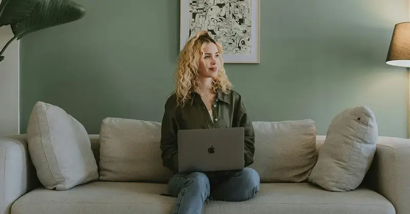 Woman on computer looking into the distance