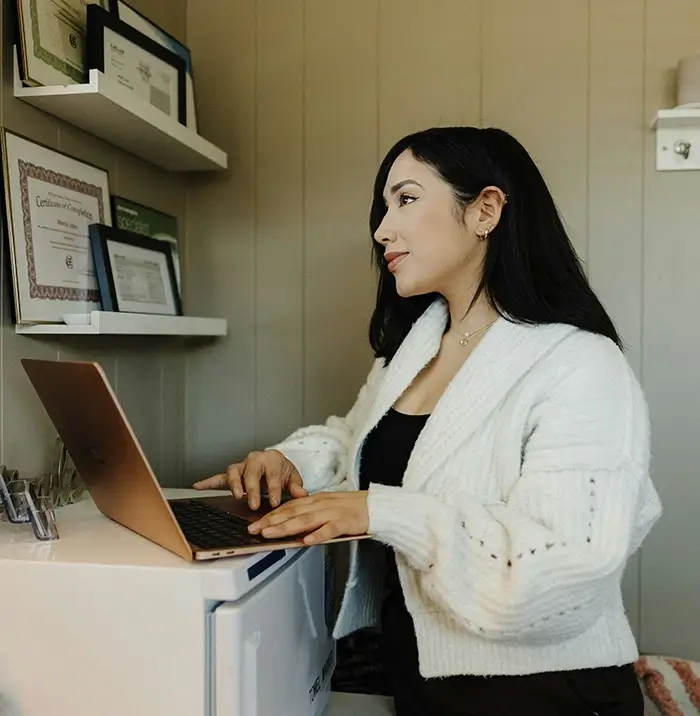 Confident woman looking at laptop